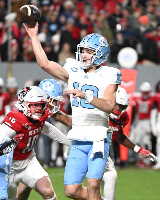 Nov 25, 2023; Raleigh, North Carolina, USA; North Carolina Tar Heels quarterback Drake Maye (10) throws a pass against North Carolina State Wolfpack linebacker Caden Fordham during the first half at Carter-Finley Stadium.